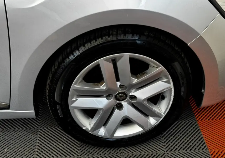 Gros plan sur la roue avant droite gris clair d'une Renault Clio Business TCe 90 2020 avec jante alliage et logo Renault central.