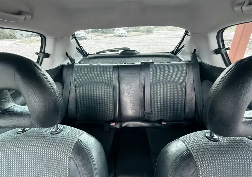 Vue intérieure arrière de la Peugeot 206 16v 2L 136CH 2003, montrant les sièges arrière en tissu et cuir noir.