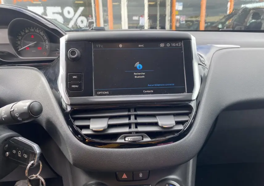 Vue rapprochée du tableau de bord de la Peugeot 208 2018 avec écran tactile et commandes centrales visibles.