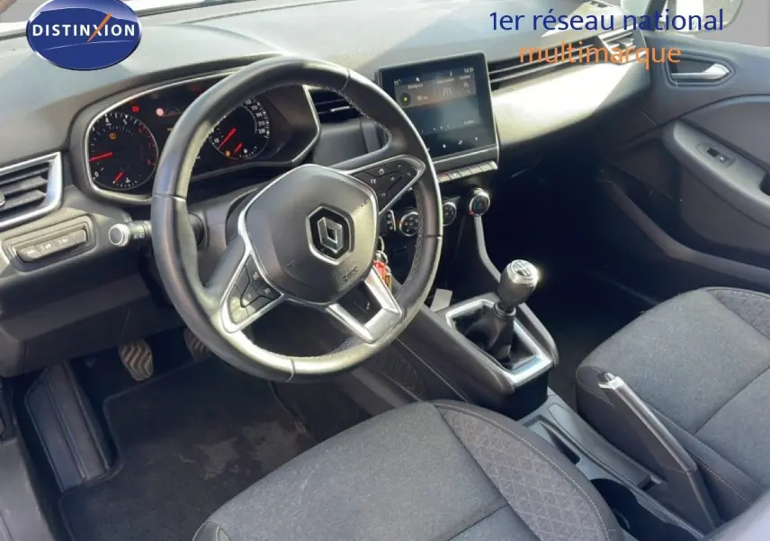 Intérieur de Renault Clio 2021 vue côté conducteur, tableau de bord moderne avec boîte manuelle et sièges tissu gris.