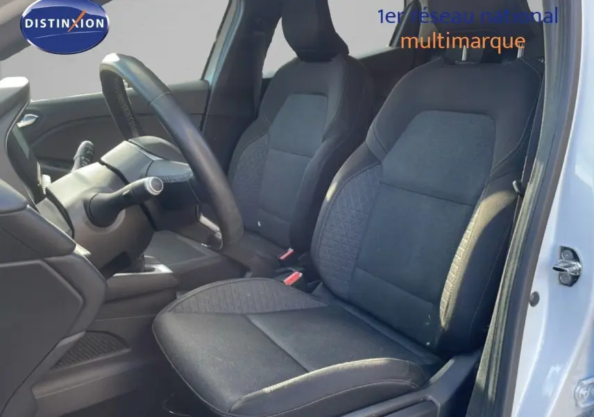 Vue intérieure côté conducteur de la Renault Clio blanche glacier 2021, sièges tissu gris noir et volant visible.