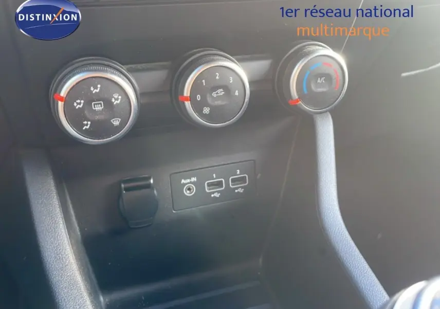 Détail des commandes de climatisation et ports USB dans l'habitacle d'une Renault Clio blanche glacier 2021.