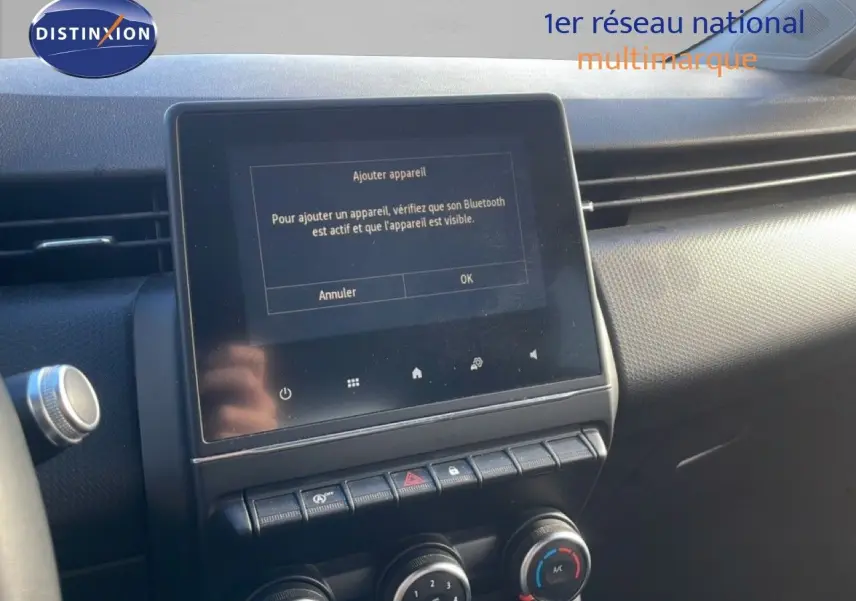 Vue rapprochée de la console centrale de la Renault Clio blanche 2021, avec écran tactile affichant la connexion Bluetooth.