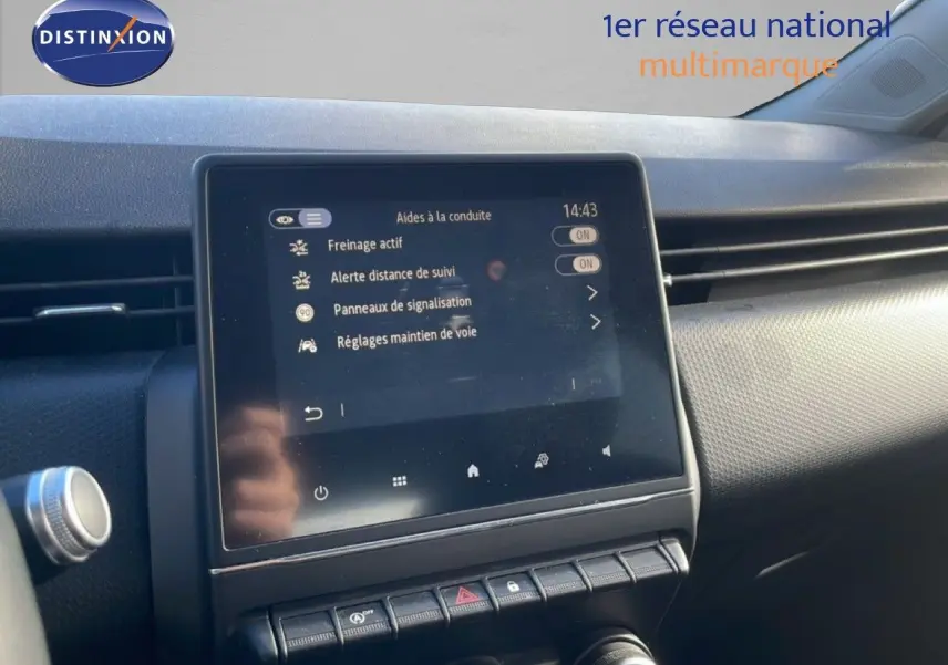 Écran tactile central affichant les aides à la conduite dans l'habitacle d'une Renault Clio blanc glacier, vue de face.