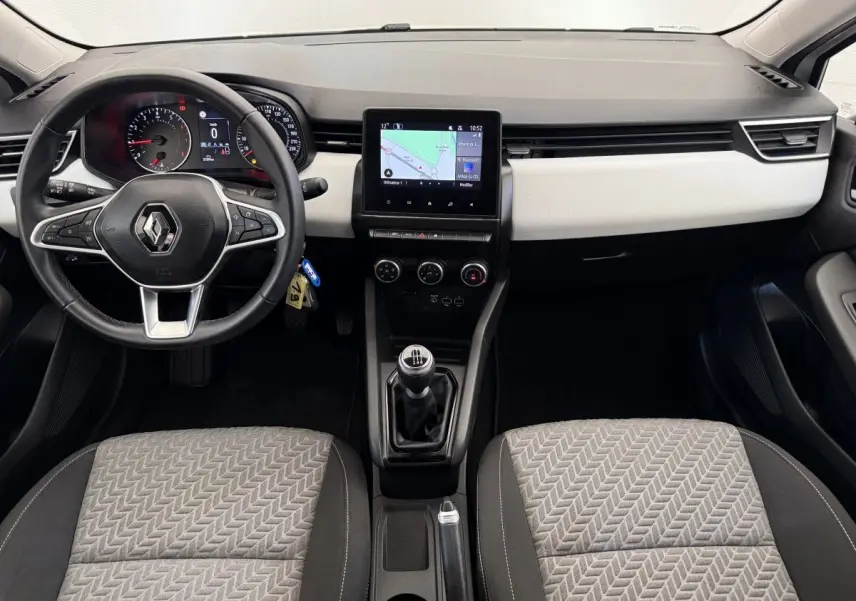 Vue intérieure avant de la Renault Clio 2023 Evolution TCe 100 GPL, tableau de bord clair avec écran tactile central et volant cuir.
