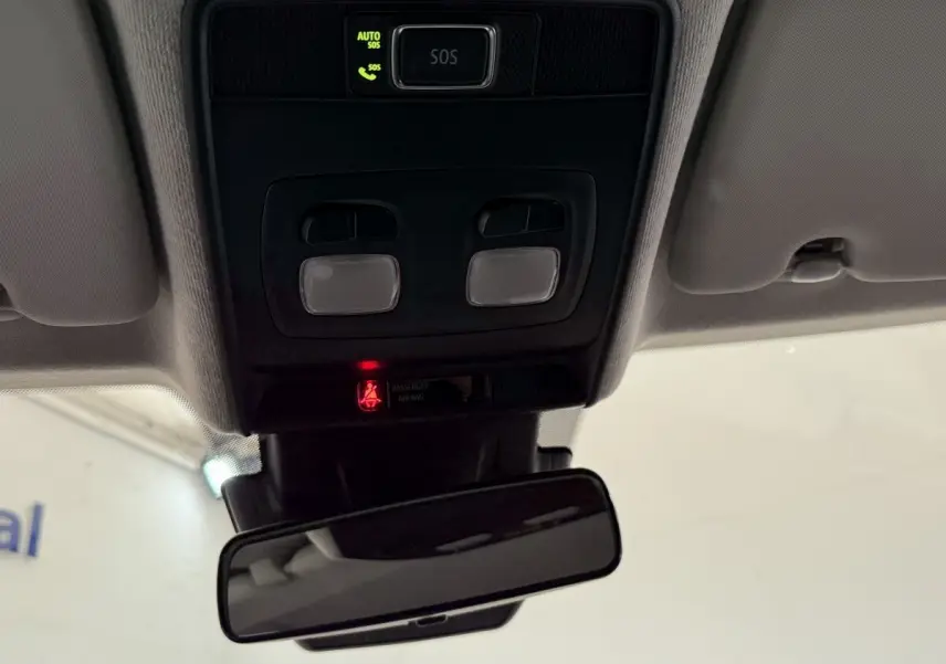 Vue intérieure du plafonnier et rétroviseur d’une Renault Clio blanche 2023 avec bouton SOS et éclairage intégré.