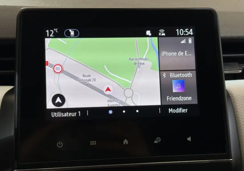 Écran tactile central de la Renault Clio blanc 2023 affichant la navigation et la connexion Bluetooth.