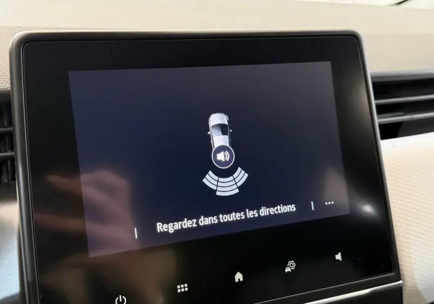 Écran tactile central de la Renault Clio 2023 affichant une alerte de détection d'obstacles en mode stationnement.