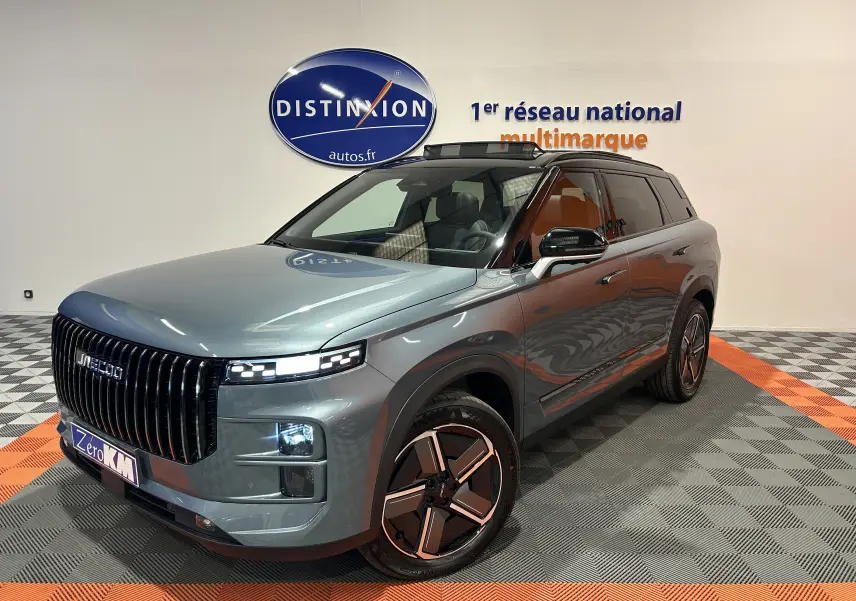 Vue 3/4 avant droit du SUV JAECOO J7 olive grey metal avec calandre verticale noire et jantes design bicolores.