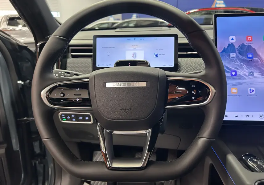 Vue frontale du volant noir du JAECOO J7 2026 avec tableau de bord numérique et écran tactile latéral.