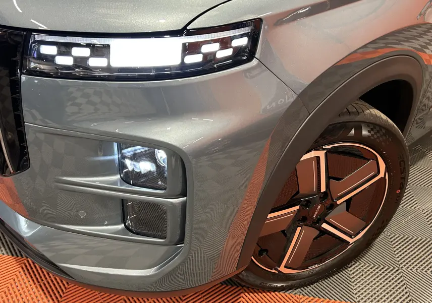 Gros plan sur l’avant droit olive grey metal du JAECOO J7 avec phares LED et jante au design futuriste.
