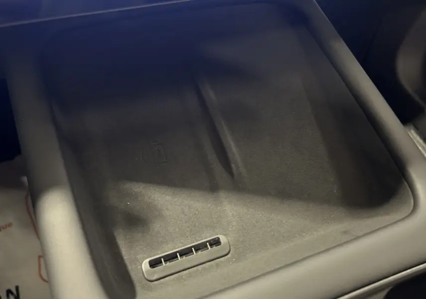 Gros plan sur le chargeur à induction noir mat dans l'habitacle du JAECOO J7 TGDI PHEV 279CH EXCLUSIVE.