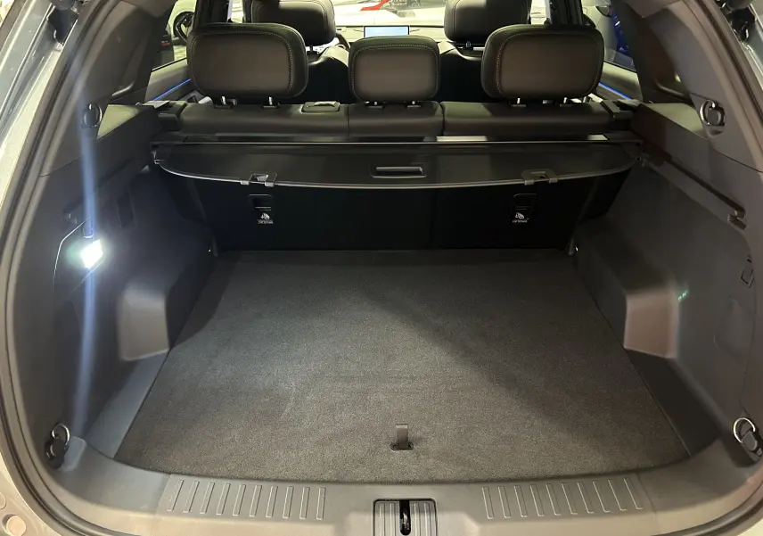 Coffre ouvert vu de l'arrière du JAECOO J7 olive grey metal, montrant un espace de chargement spacieux et banquette arrière noire.