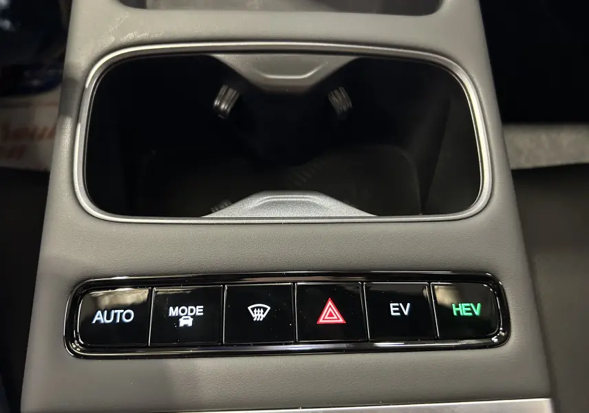 Gros plan sur la console centrale grise olive du JAECOO J7 avec boutons de mode de conduite et alertes lumineux.