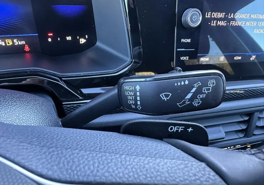 Gros plan sur la manette d’essuie-glace à gauche du volant dans l’habitacle du Volkswagen Taigo bleu Recife 2025.