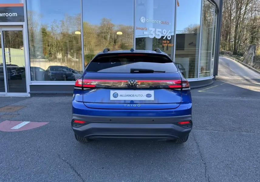 Vue arrière du Volkswagen Taigo bleu Recife 2025, avec feux LED reliés et lunette arrière teintée.