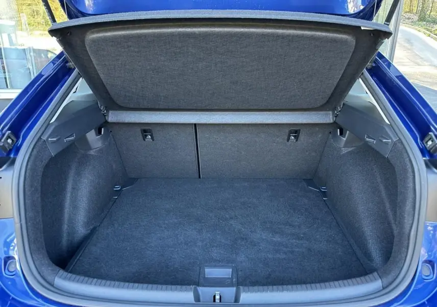 Coffre ouvert vu de l'arrière d'un Volkswagen Taigo bleu Recife, montrant un espace de chargement propre et spacieux.
