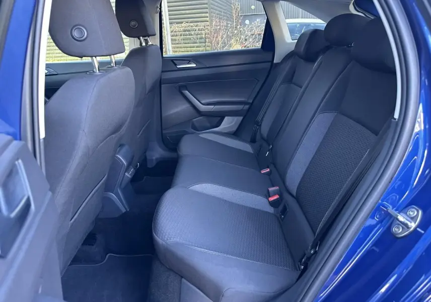Vue intérieure côté droit des sièges arrière en tissu gris foncé du Volkswagen Taigo Bleu Recife 2025.