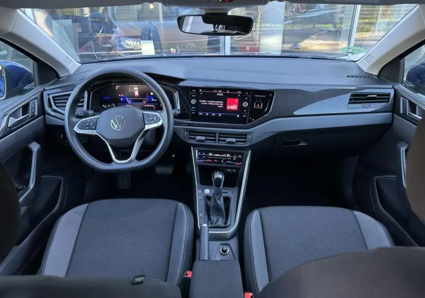 Vue intérieure frontale du tableau de bord et volant du Volkswagen Taigo 2025 avec écran tactile et console centrale noire.