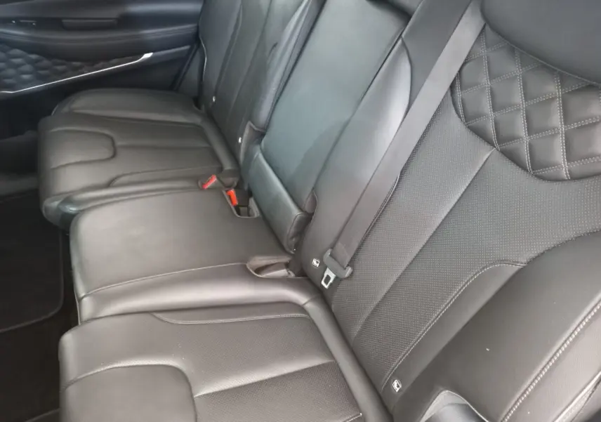 Vue rapprochée de la banquette arrière en cuir noir du Hyundai Santa Fe 2022 avec surpiqûres losanges et ceintures grises.