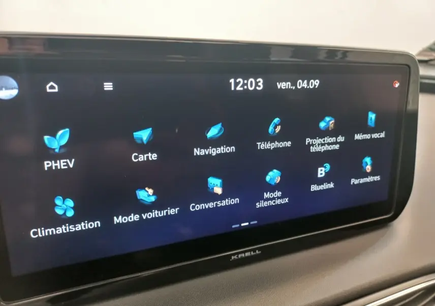 Écran tactile central du Hyundai Santa Fe gris clair, affichant le menu principal avec icônes bleues, vue intérieure.