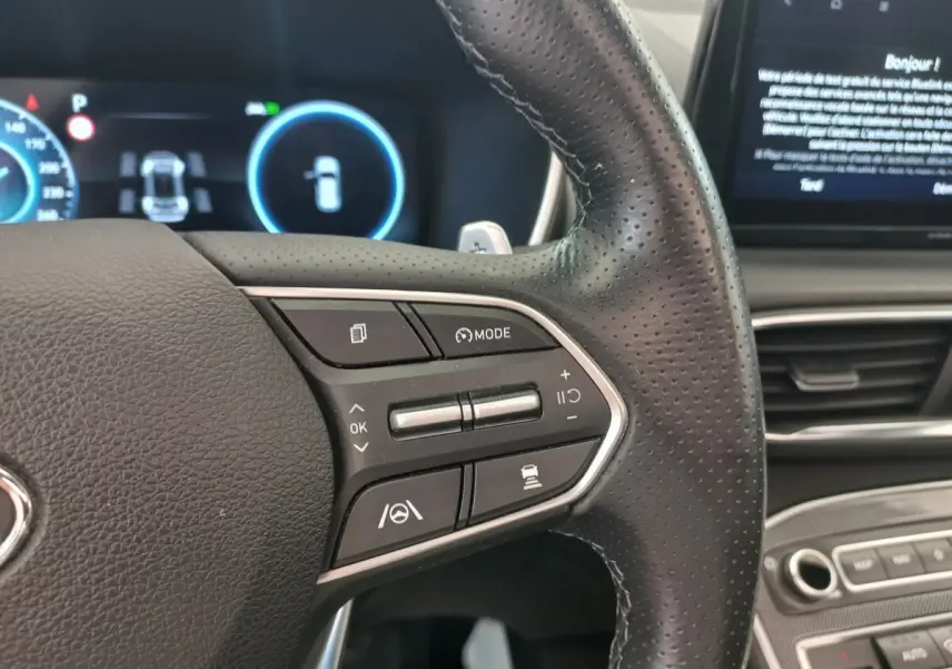 Gros plan sur le volant cuir multifonctions du Hyundai Santa Fe 2022, avec commandes de régulateur et assistance à la conduite.