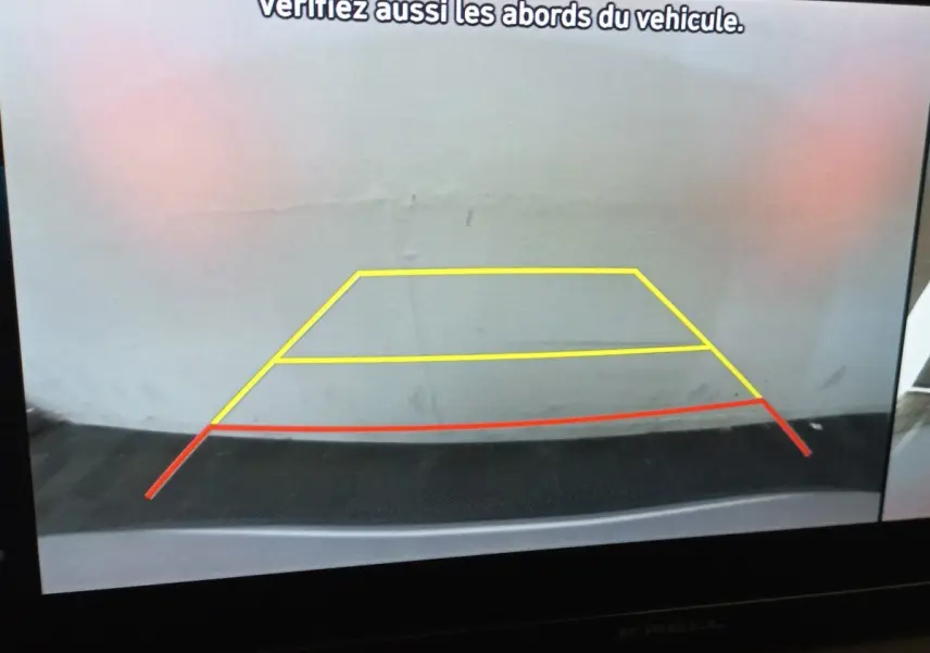 Image de la caméra de recul du Hyundai Santa Fe 2022, affichant les lignes de guidage jaunes et rouges sur fond gris.