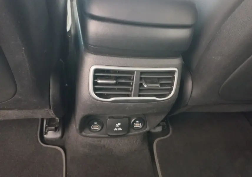 Détail de la console arrière noire avec bouches d’aération et prises USB du Hyundai Santa Fe gris clair 2022.