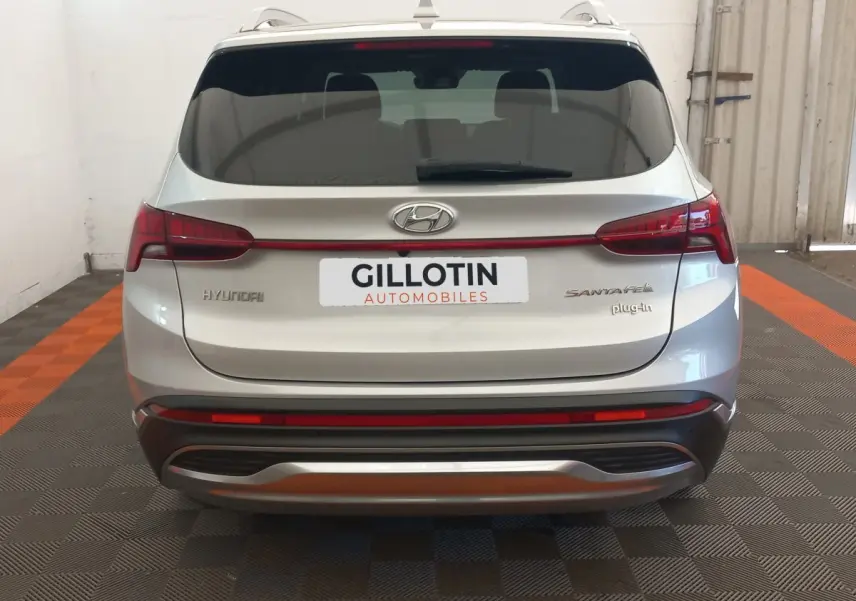 Vue arrière d’un Hyundai Santa Fe gris clair hybride rechargeable avec feux LED et logo plug-in visible.