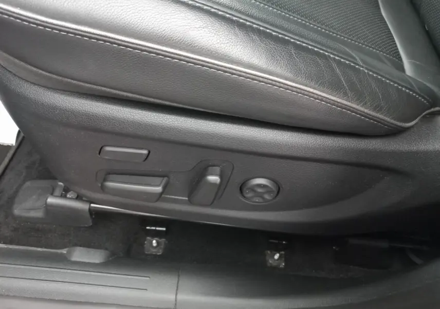 Gros plan sur les commandes de réglage électrique du siège en cuir noir côté conducteur du Hyundai Santa Fe gris clair 2022.
