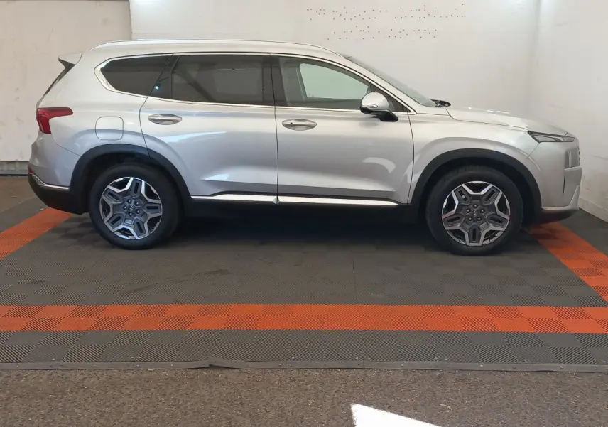 Vue de profil côté droit d'un Hyundai Santa Fe gris clair 2022 avec jantes alliage et toit ouvrant électrique.