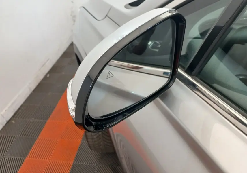 Rétroviseur côté gauche gris clair du Hyundai Santa Fe 2022 avec clignotant intégré, vue rapprochée en intérieur.