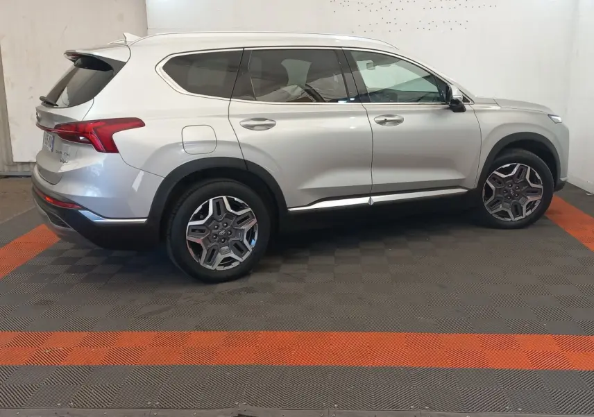Vue latérale droite d'un Hyundai Santa Fe gris clair avec jantes alliage et toit ouvrant électrique.