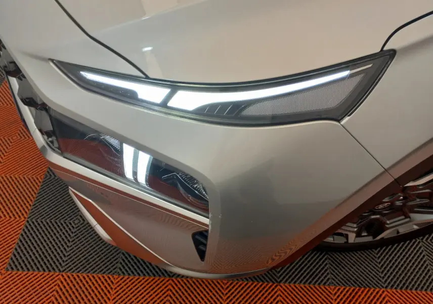 Gros plan sur l’avant droit gris clair du Hyundai Santa Fe 2022 avec phares LED allumés et calandre distinctive.