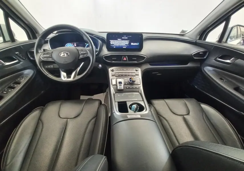 Vue intérieure avant du Hyundai Santa Fe 2022 gris clair, avec volant cuir multifonctions et écran tactile central.