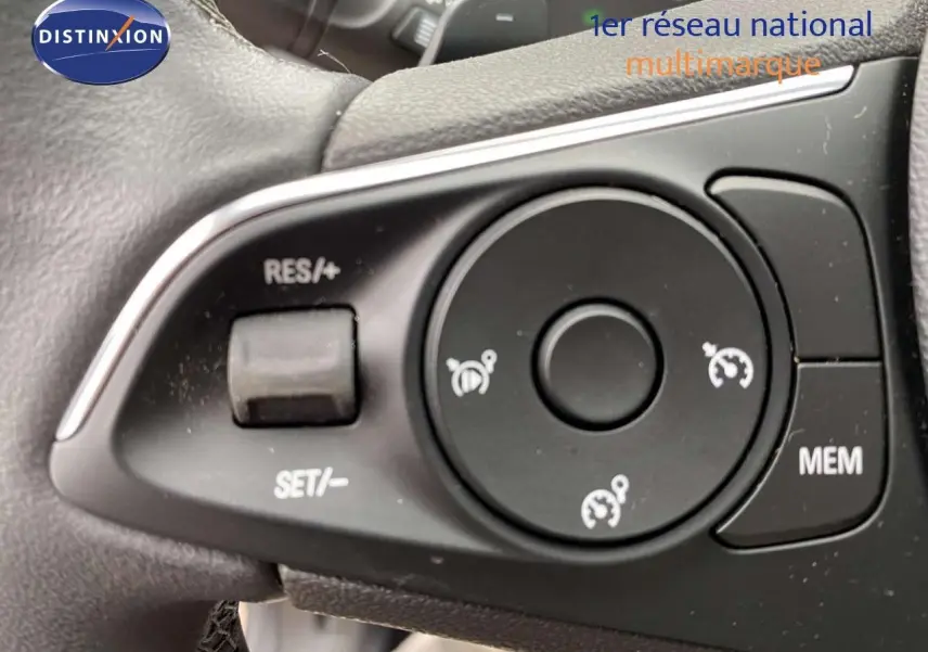 Gros plan sur les commandes de régulateur de vitesse au volant d'un Opel Grandland X gris Moai Metal 2021.
