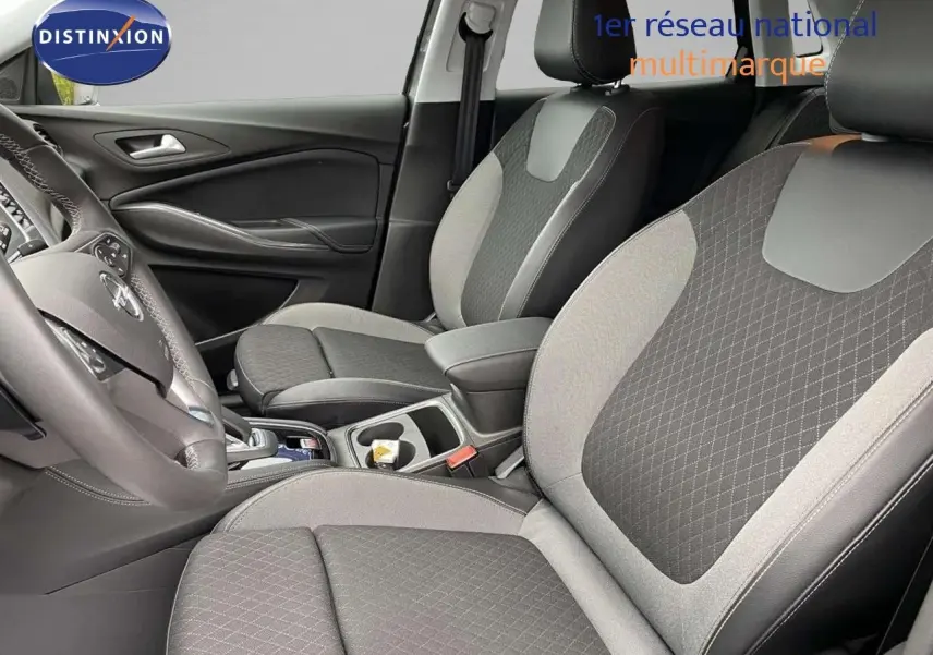 Intérieur avant de l'Opel Grandland X gris Moai Metal, sièges tissu et cuir noir avec console centrale visible.