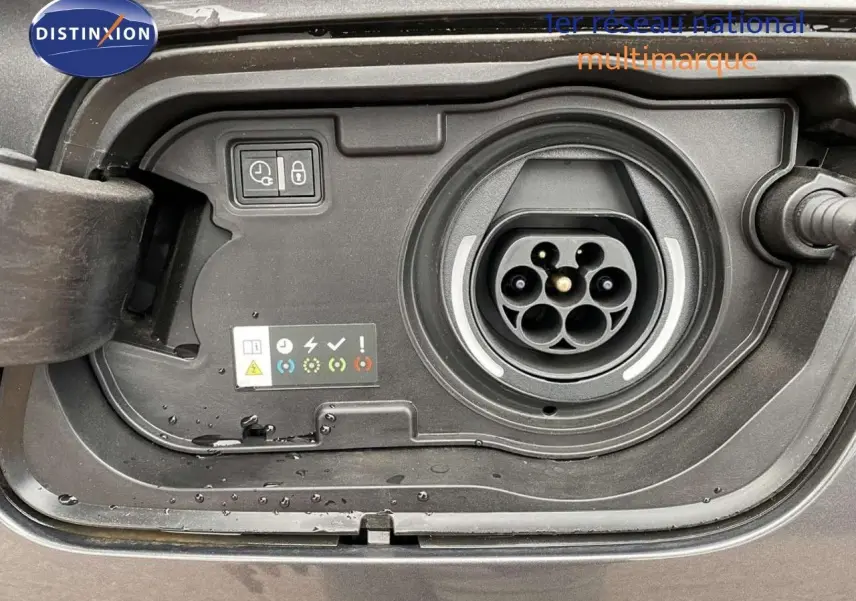 Prise de recharge hybride en gros plan sur un Opel Grandland X gris Moai Metal, montrant les connecteurs et indicateurs.