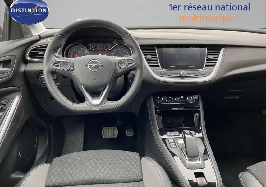 Intérieur de l’Opel Grandland X gris Moai Metal, vue centrée sur le volant et la console centrale moderne.