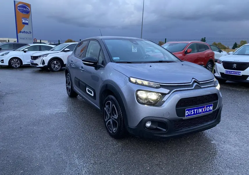 Citroën C3 gris Artense vue 3/4 avant droit sous pluie avec jantes alu 16 pouces et Airbump noirs.