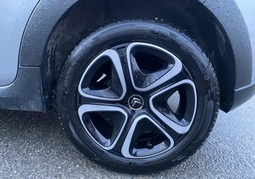 Gros plan sur la jante alu 16 pouces diamantée noire et grise du côté arrière droit d'une Citroën C3 gris Artense.