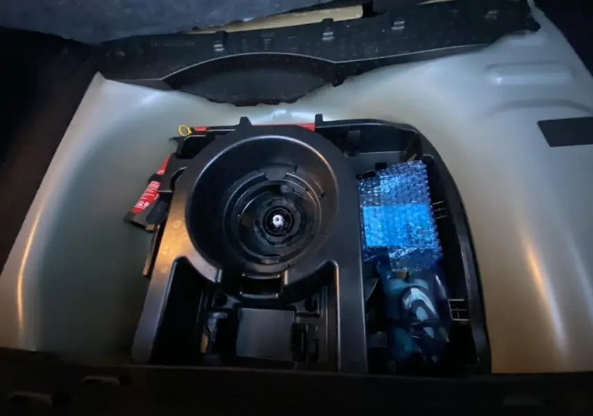 Vue rapprochée du coffre d'une Citroën C3 2022 gris Artense montrant le rangement sous plancher avec outils et kit de réparation.