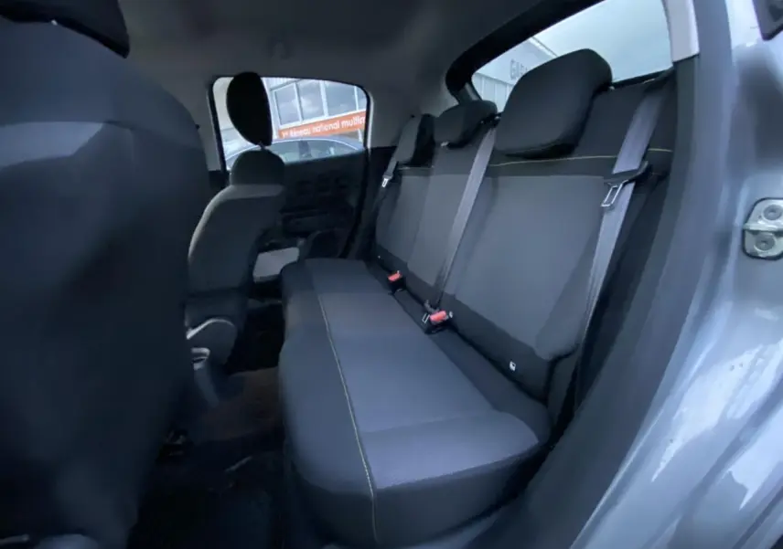 Vue intérieure arrière côté droit du Citroën C3 gris Artense 2022, banquette noire avec surpiqûres jaunes et ceintures grises.