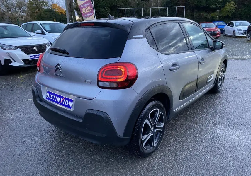 Vue 3/4 arrière droite d'une Citroën C3 gris Artense avec toit noir et jantes alliage diamantées.