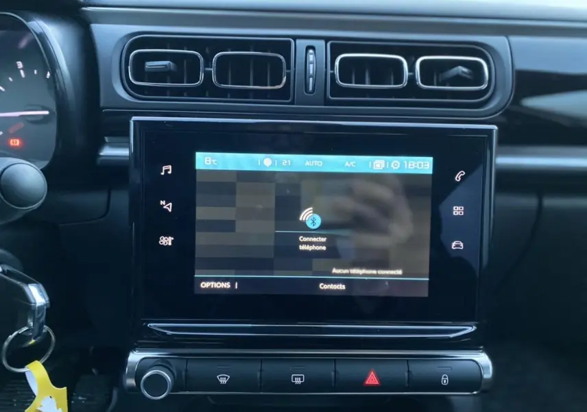Vue rapprochée de la tablette tactile 7 pouces du tableau de bord de la Citroën C3 gris Artense 2022 avec commandes audio.