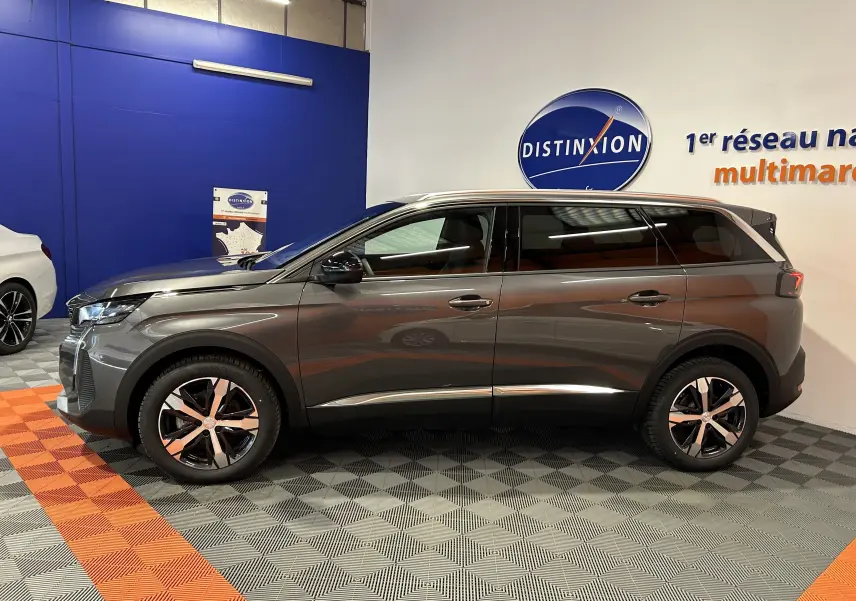 Peugeot 5008 BlueHDi 130 gris Platinium vue de profil côté gauche en intérieur showroom avec jantes bi-ton.