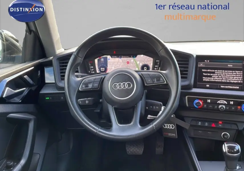 Vue intérieure du poste de conduite de l'Audi A1 Sportback 2023 avec volant multifonction et écran digital.
