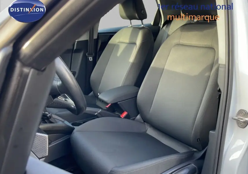 Vue intérieure côté conducteur de l'Audi A1 Sportback 2023 blanc glacier, sièges tissu gris et volant visible.