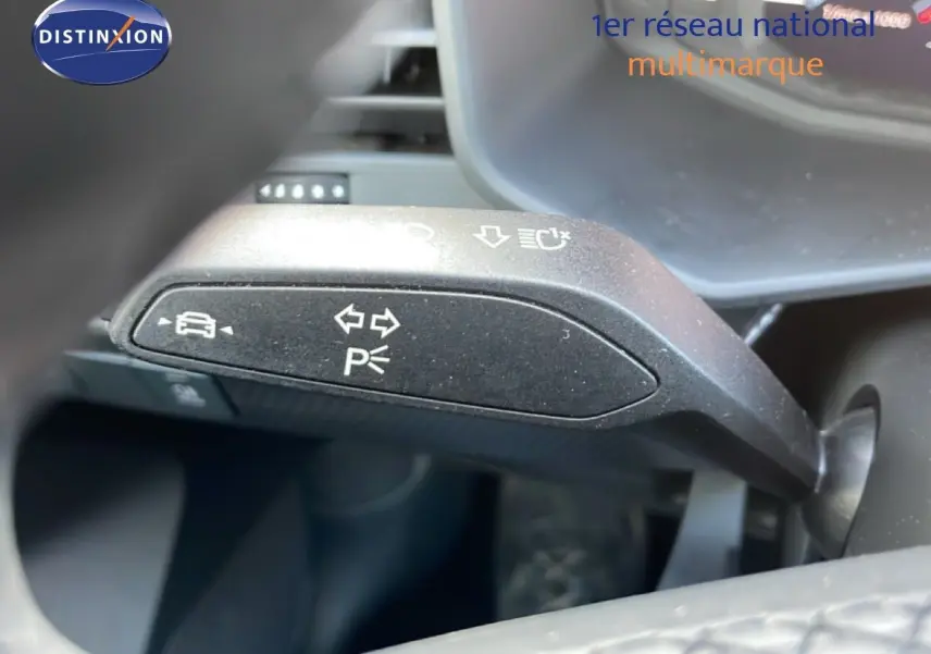 Le levier de clignotant et feux de stationnement d'une Audi A1 Sportback 2023 vue côté conducteur.