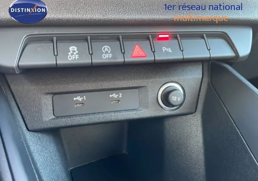 Vue rapprochée de la console centrale d'une Audi A1 Sportback blanche, montrant les commandes et ports USB.